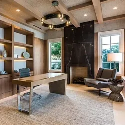 Upscale home office with wood beams, built-in shelves and fireplace